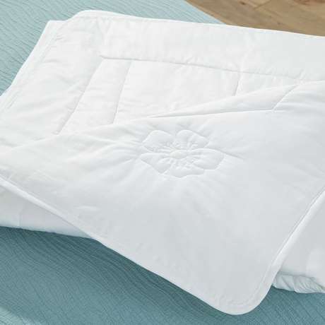 Eastman Heritage white down comforter with floral embroidery and quilted stitching providing layers of natural comfort for a legendary lifestyle.