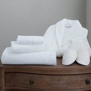 Eastman Heritage spa set including a white plush bathrobe and stacked towels offering layers of natural comfort for an elegant and luxury lifestyle.